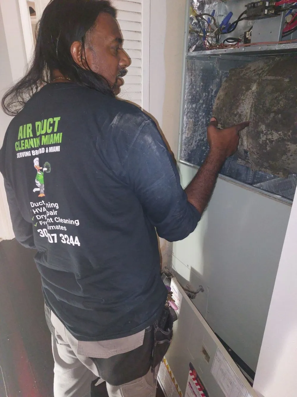 Licensed Air Duct Cleaning Miami technician showing a dirty AC system