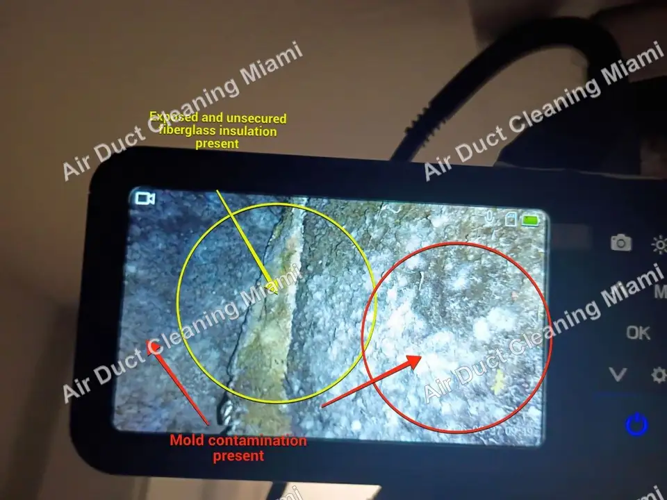 Duct camera screen showing signs of mold and loose fiberglass inside an air duct, documented for the written report