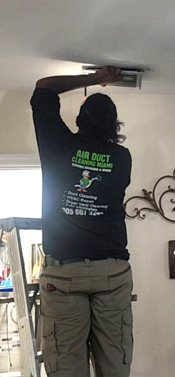 Technician removing AC vent covers from ceiling for cleaning